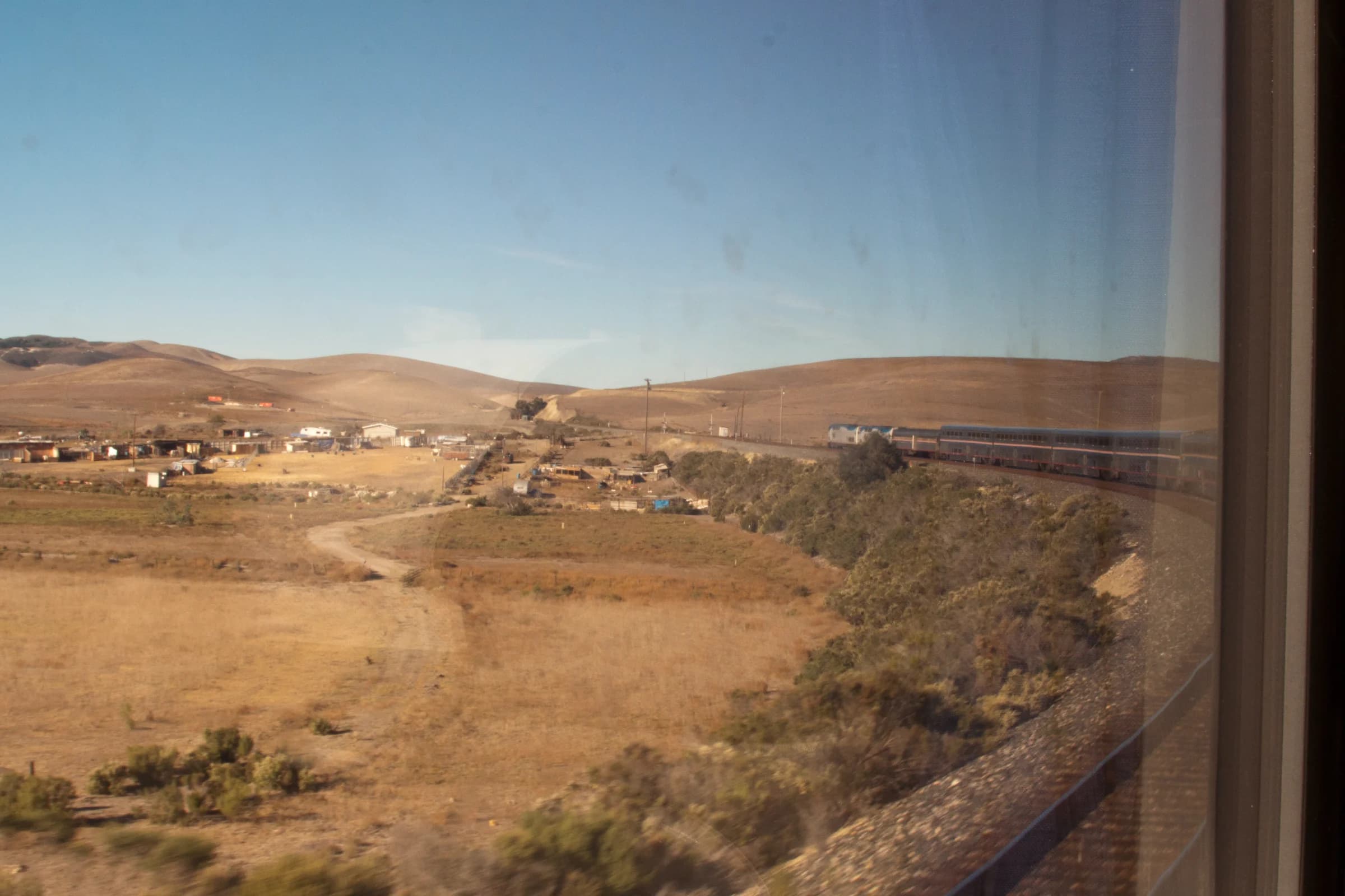 Amtrak Coast Starlight Train rounding a curve as seen from an end carriage